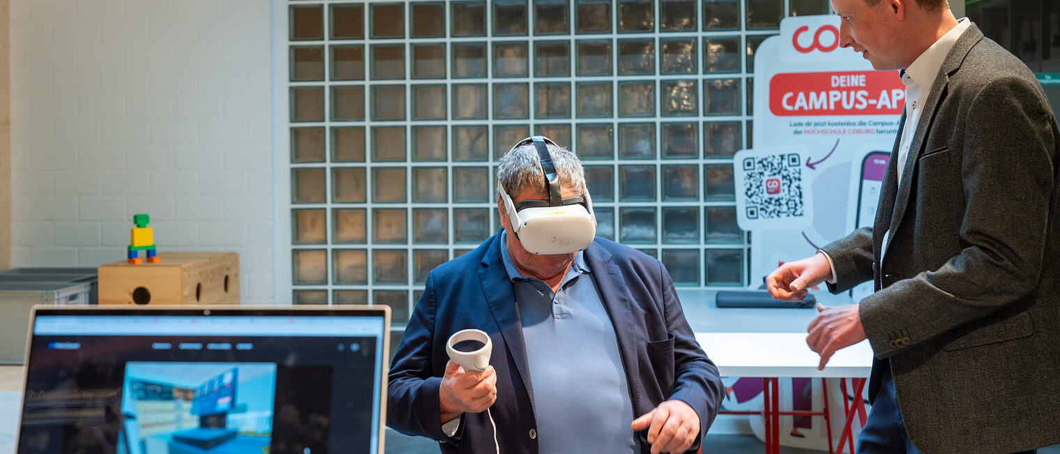 Kreishandwerksmeister Mathias Söllner (links), selbst Bäckermeister, testet die von Prof. Jens Grubert (Hochschule Coburg) programmierte VR-Software, mit der Auszubildende im Fachverkauf und angehendes Verkaufspersonal herausfordernde Verkaufssituationen realistisch und wirksam üben können. 