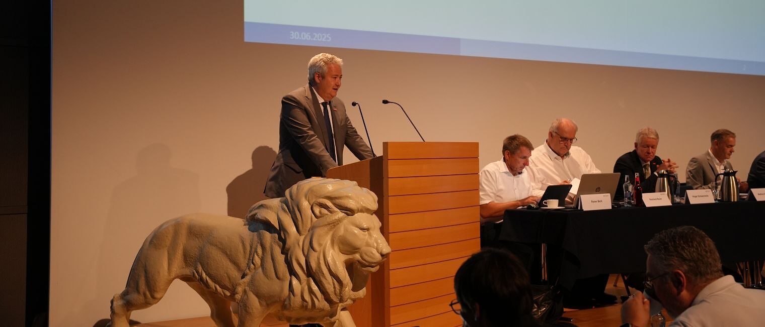 Präsident Graßmann hält einen Vortrag am Podium.