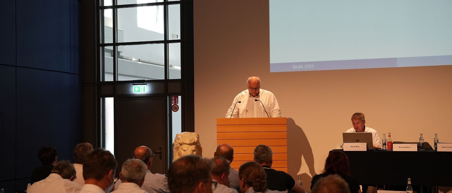 Hauptgeschäftsführer Reinhard Bauer hält einen Vortrag am Rednerpult.