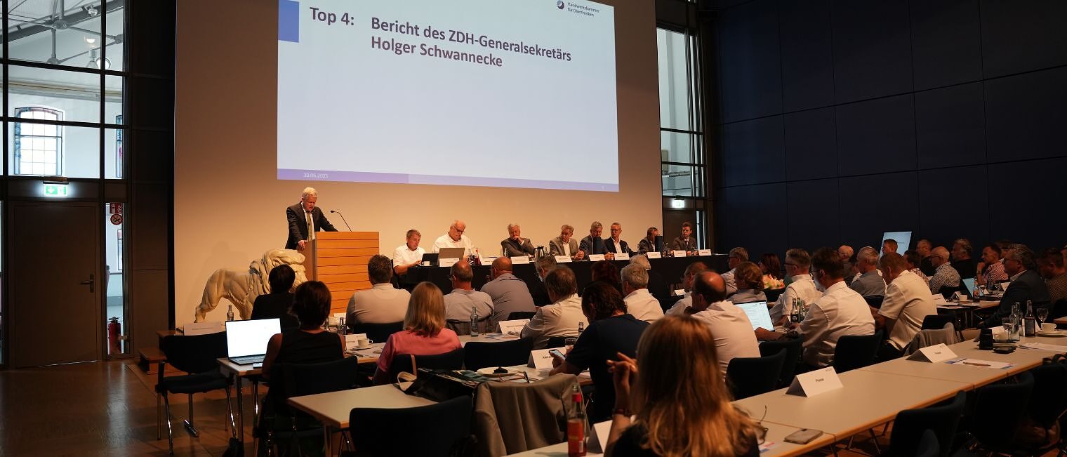Holger Schwannecke stellt seinen Bericht vor der Vollversammlung der Handwerkskammer in einem Sitzungssaal vor. 