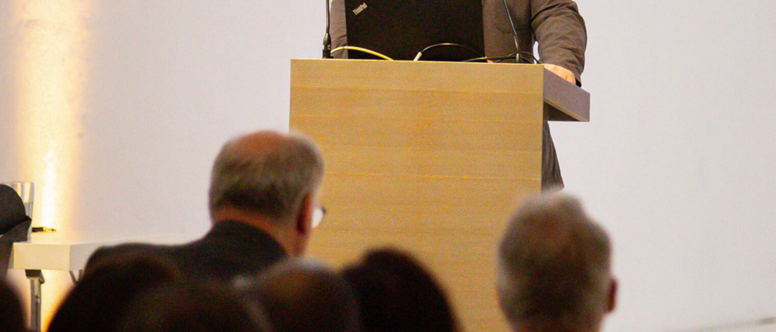 Johannes Lange spricht am Rednerpult zum Publikum.