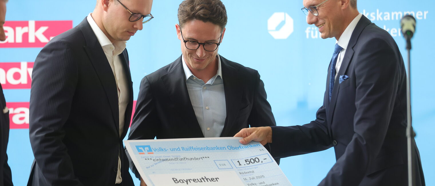 VR-Bank Vorsitzender Joachim Hausner übergibt Marius Körlin und Tom Hillgruber ihre Siegerurkunde.