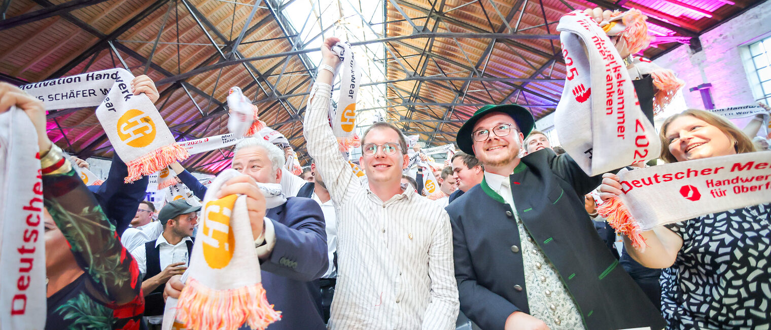 Matthias Graßmann und Meisterinnen und Meister jubeln mit ihren Meisterschals in der Glasschleif