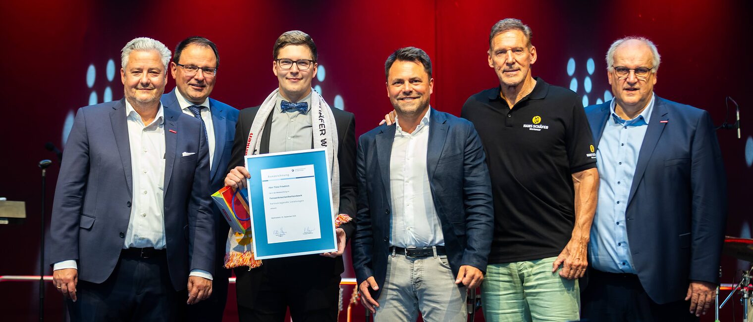 Feinwerkmechanikermeister Timo Friedrich präsentiert seine Bestenurkunde zusammen mit Matthias Graßmann, Martin Schöffel, Andreas Grewe, Ralf Moeller und Reinhard Bauer