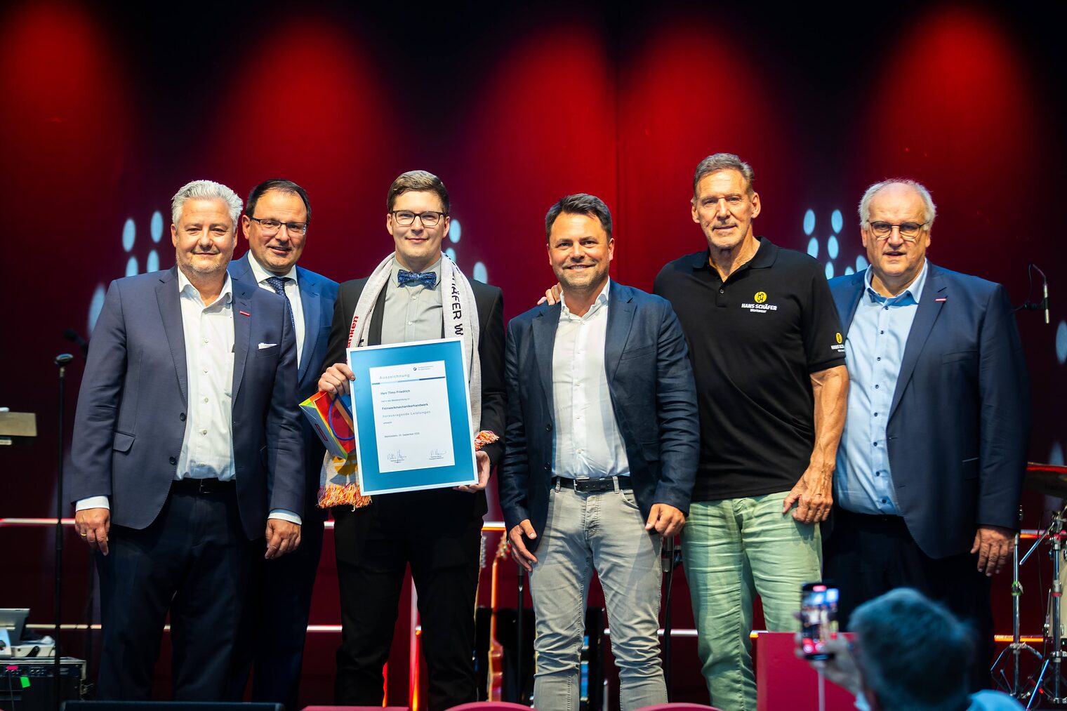 Feinwerkmechanikermeister Timo Friedrich präsentiert seine Bestenurkunde zusammen mit Matthias Graßmann, Martin Schöffel, Andreas Grewe, Ralf Moeller und Reinhard Bauer