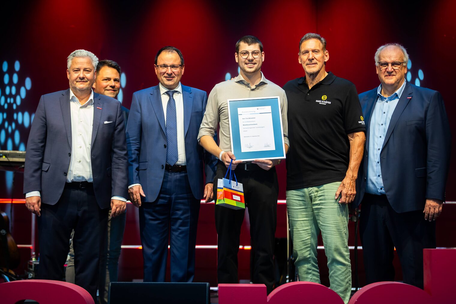 Metallbauermeister Tim Wöstefeld präsentiert seine Urkunde mit Reinhard Bauer, Matthias Graßmann, Andreas Grewe, Martin Schöffel und Ralf Moeller