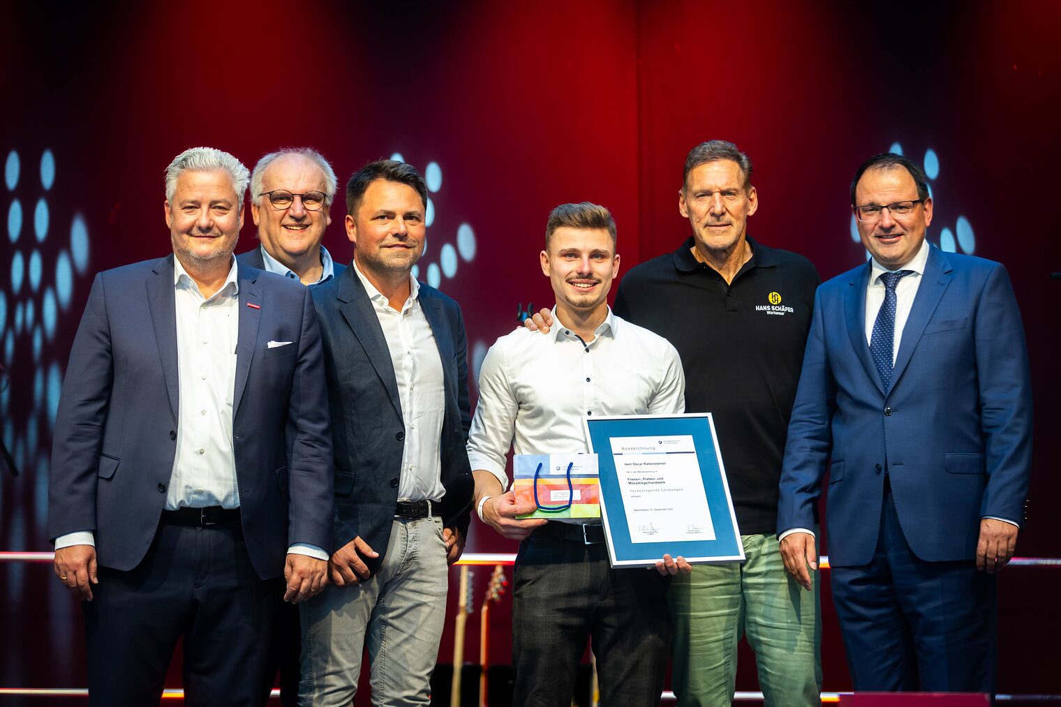 Fliesenlegermeister Oscar Rabensteiner präsentiert seine Bestenurkunde mit Matthias Graßmann, Reinhard Bauer, Andreas Grewe, Ralf Moeller, Martin Schöffel