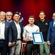Fliesenlegermeister Oscar Rabensteiner präsentiert seine Bestenurkunde mit Matthias Graßmann, Reinhard Bauer, Andreas Grewe, Ralf Moeller, Martin Schöffel