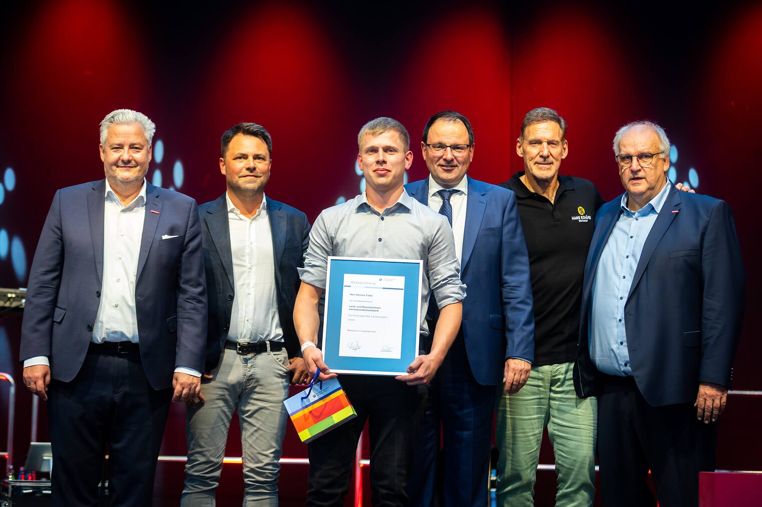 Land- und Baumaschinenmechatronikermeister Hannes Faatz präsentiert ihre Bestenurkunde mit Matthias Graßmann, Reinhard Bauer, Andreas Grewe, Ralf Moeller und Martin Schöffel.