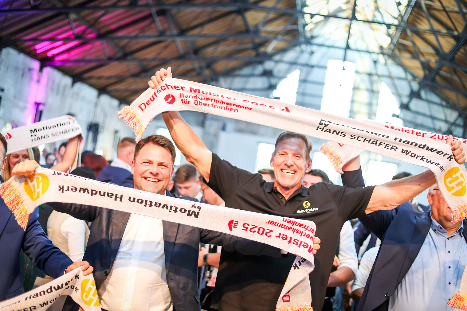 Ralf Moeller und Andreas Grewe jubeln mit den Meisterinnen und Meistern und Meisterschals.