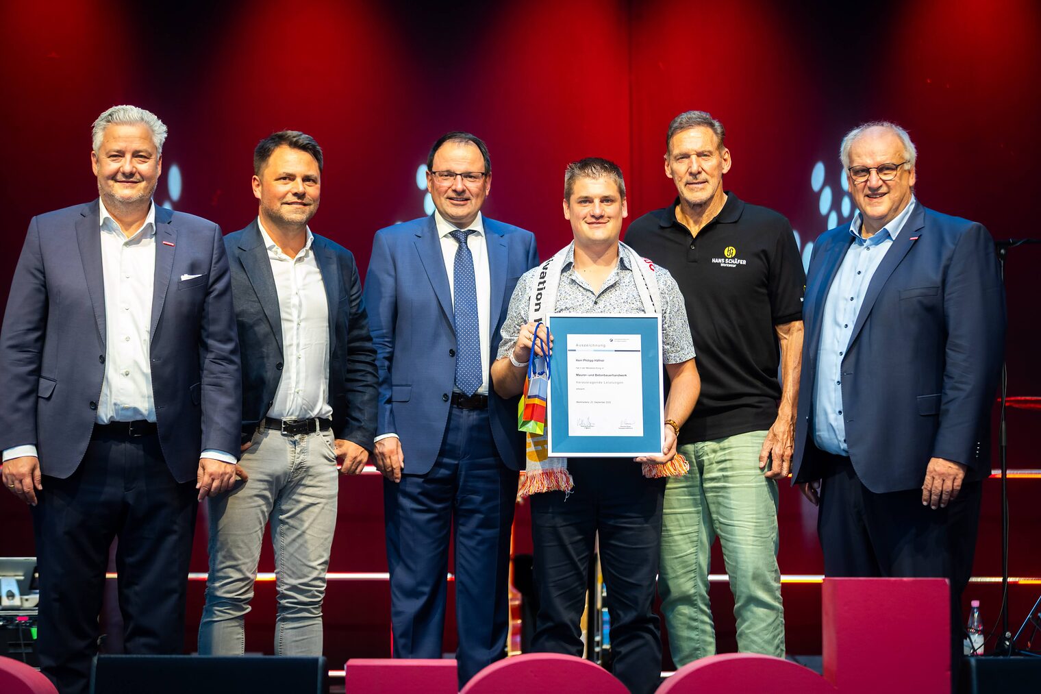 Maurer- und Betonbauermeister Philipp Häfner präsentiert seine Bestenurkunde mit Matthias Graßmann, Andreas Grewe, Martin Schöffel, Ralf Moeller und Reinhard Bauer.