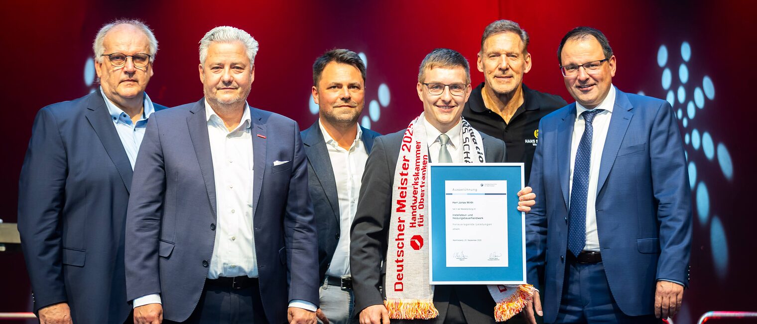 Installateur- und Heizungsbauermeister Jonas Wirth präsentiert seine Bestenurkunde mit Reinhard Bauer, Matthias Graßmann, Andreas Grewe, Ralf Moeller und Andeas Schöffel