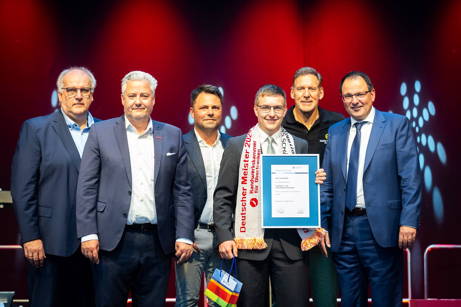 Installateur- und Heizungsbauermeister Jonas Wirth präsentiert seine Bestenurkunde mit Reinhard Bauer, Matthias Graßmann, Andreas Grewe, Ralf Moeller und Andeas Schöffel