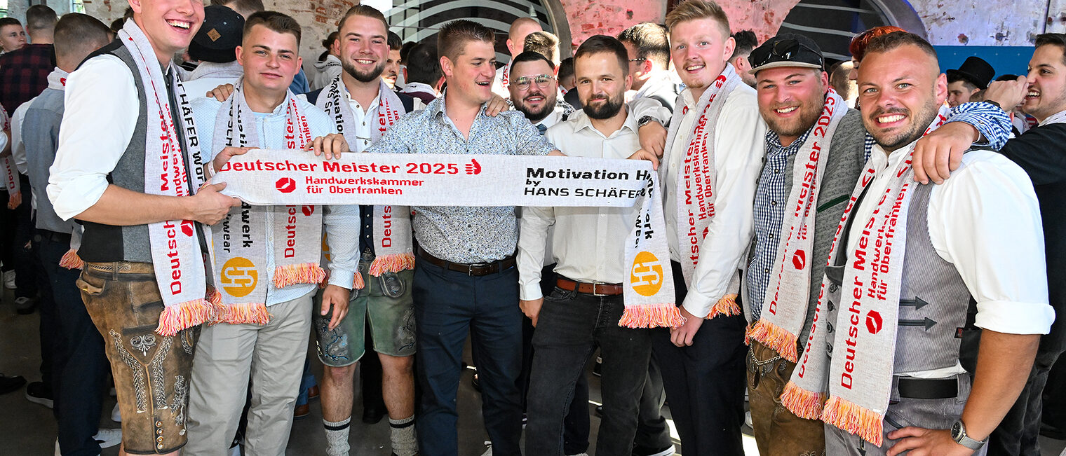 Eine Gruppe Meister posiert mit einem Meisterschal.