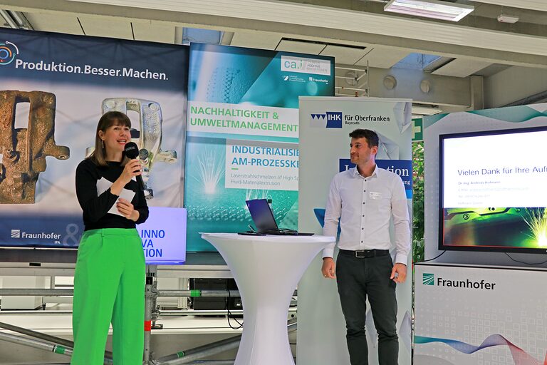 Annegret Schnick spricht neben Doktor Hofmann in ein Mikrofon im Keylab Additive Innovationen.