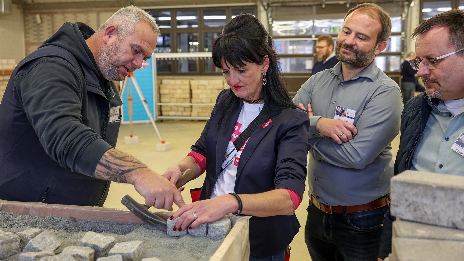 Ein Jugendlicher schweißt ein zwei Metallrohre zusammen.