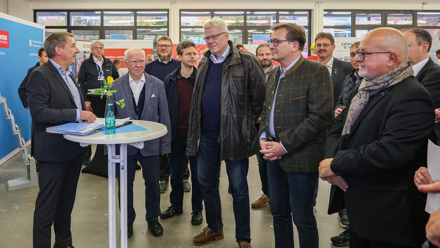 Die Ehrengäste auf der Berufsmesse hören HWK -Geschäftsführer Rainer Beck zu.