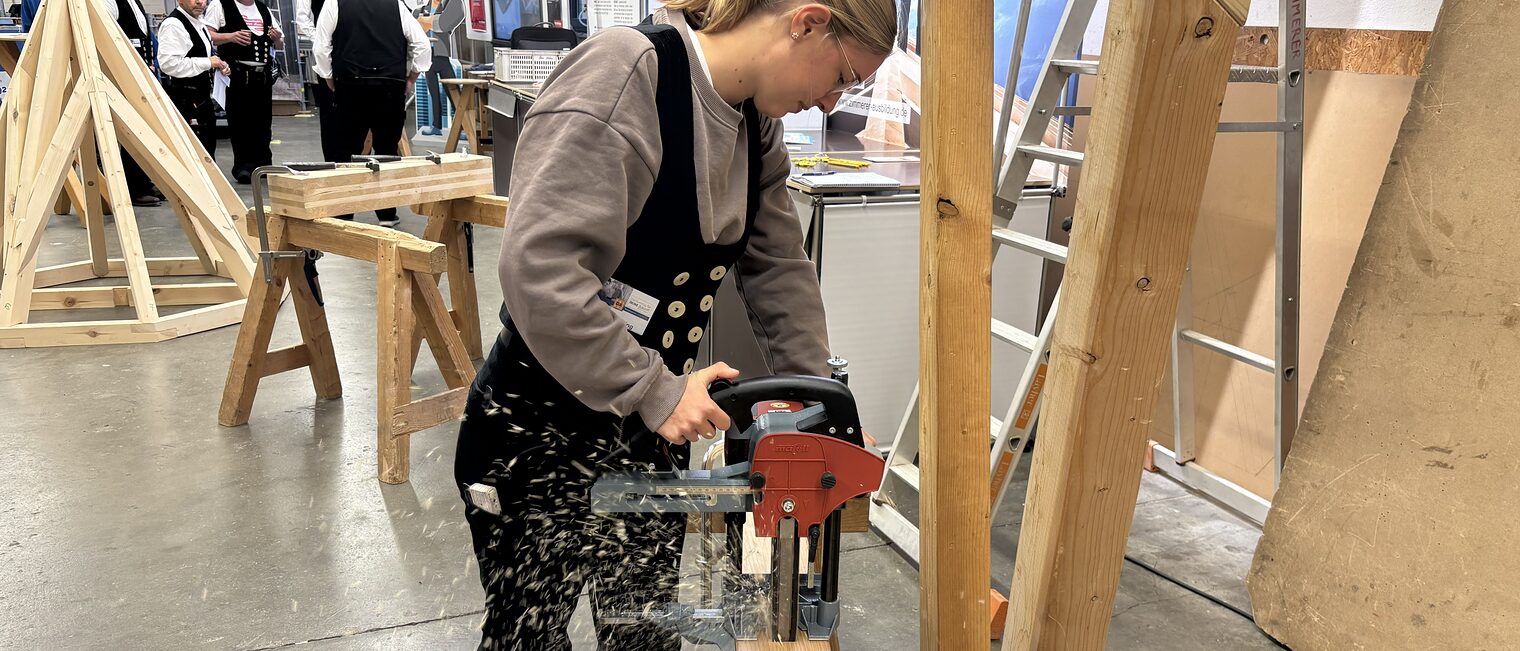 Eine Auszubildende fräst mit einer Stemmmaschine ein Zapfenloch. 