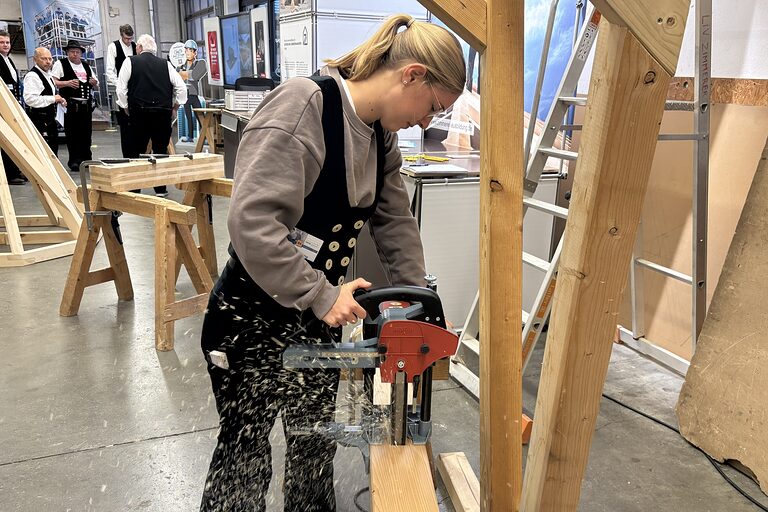 Eine Auszubildende fräst mit einer Stemmmaschine ein Zapfenloch. 