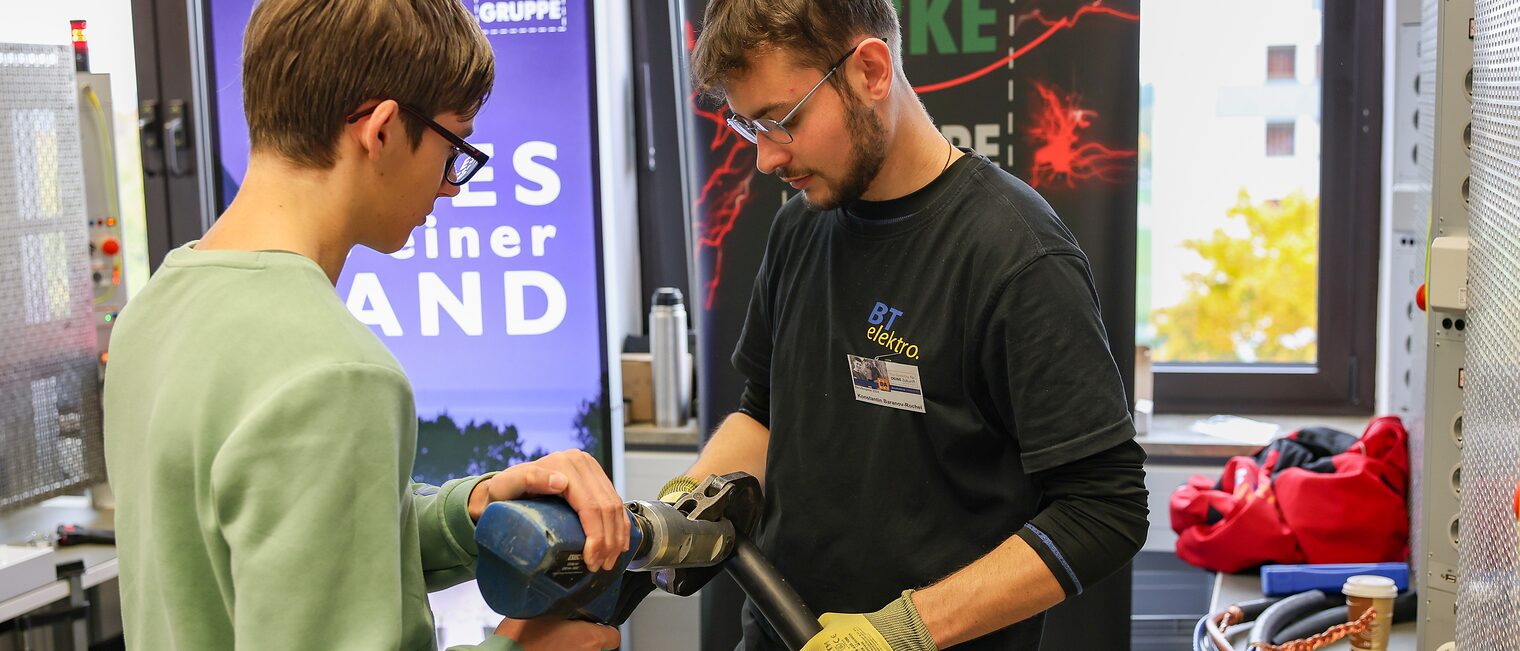 Ein Jugendlicher klemmt ein Industriekabel ab.