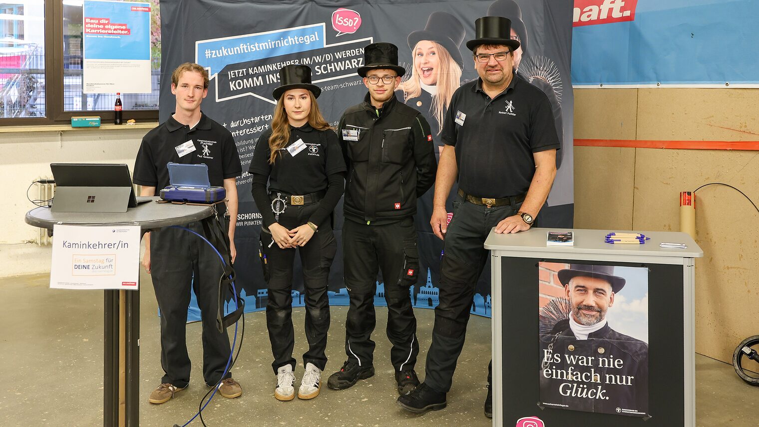 Das Team der Schornsteinfegerinnung steht an seinem Stand auf der Berufsmesse.