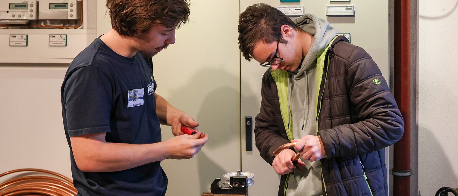 Ein Jugendlicher wischt ein Metallrohr ab.