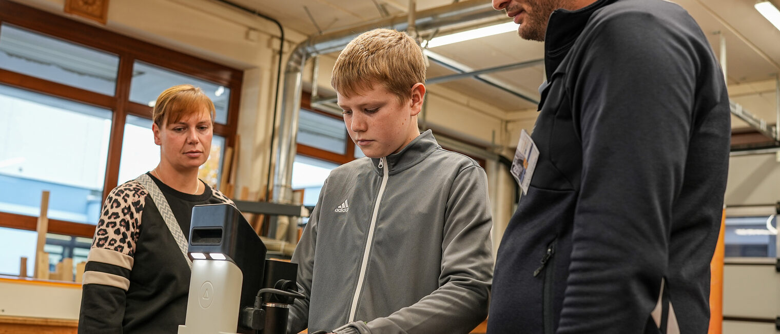 Ein Jugendlicher stanzt seinen Namen in einen Holzstern ein.