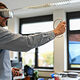 Ein junger Mann trägt eine VR-Brille und hält einen Controller in der Hand.