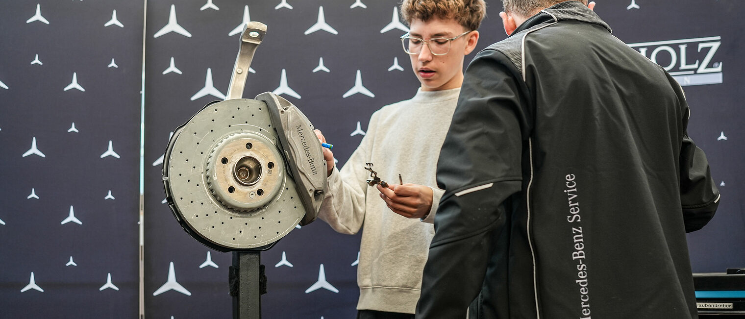 Ein Jugendlicher werkelt an einem Motor.