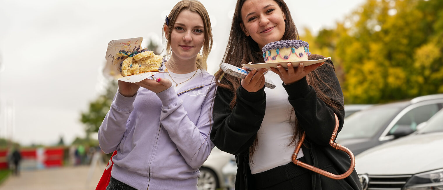 Zwei Jugendliche präsentieren stolz ihre Torten.