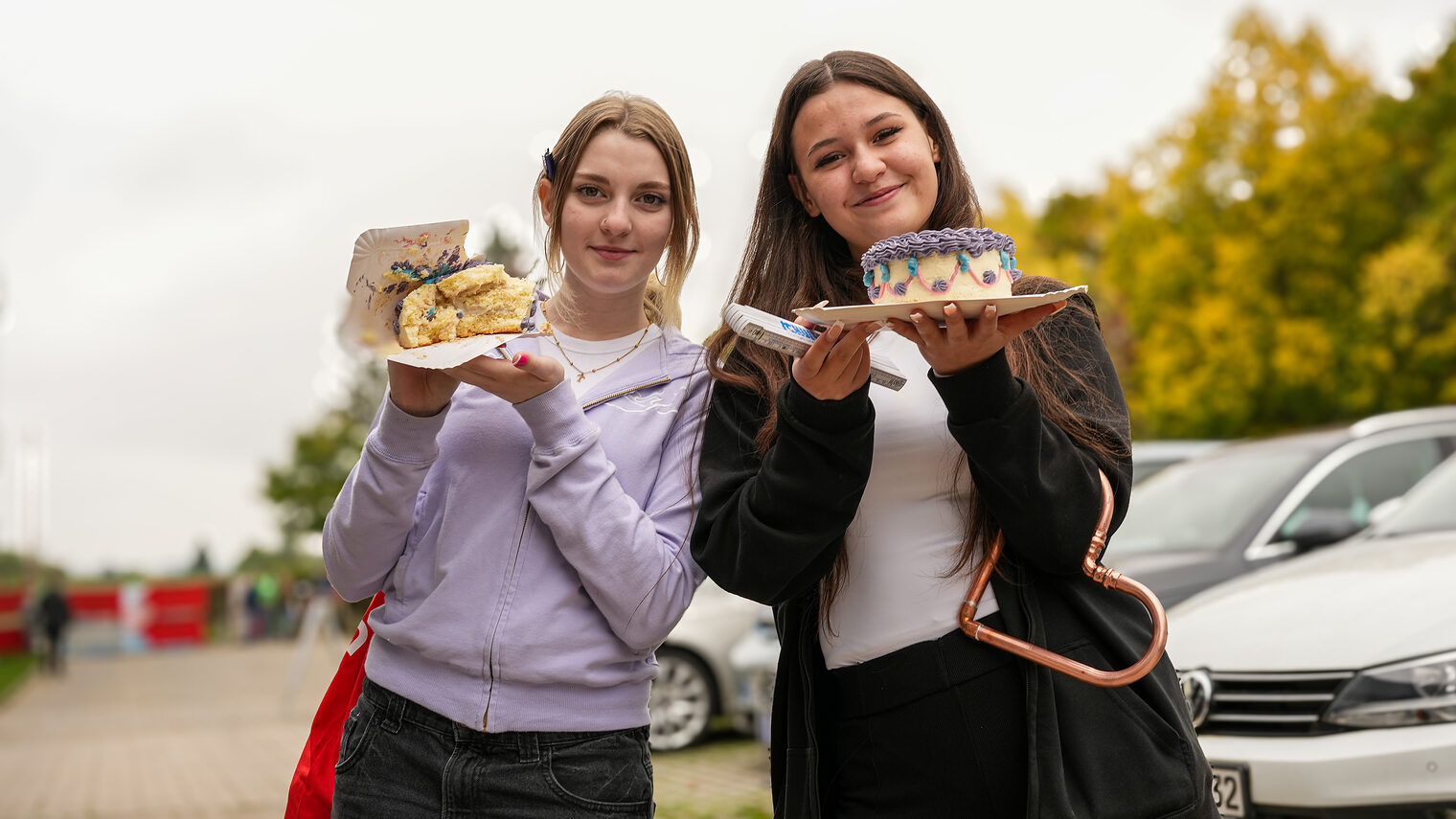Zwei Jugendliche präsentieren stolz ihre Torten.