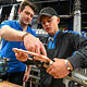 Ein Jugendlicher biegt eine Verbindung mit Kupferrohren zurecht.