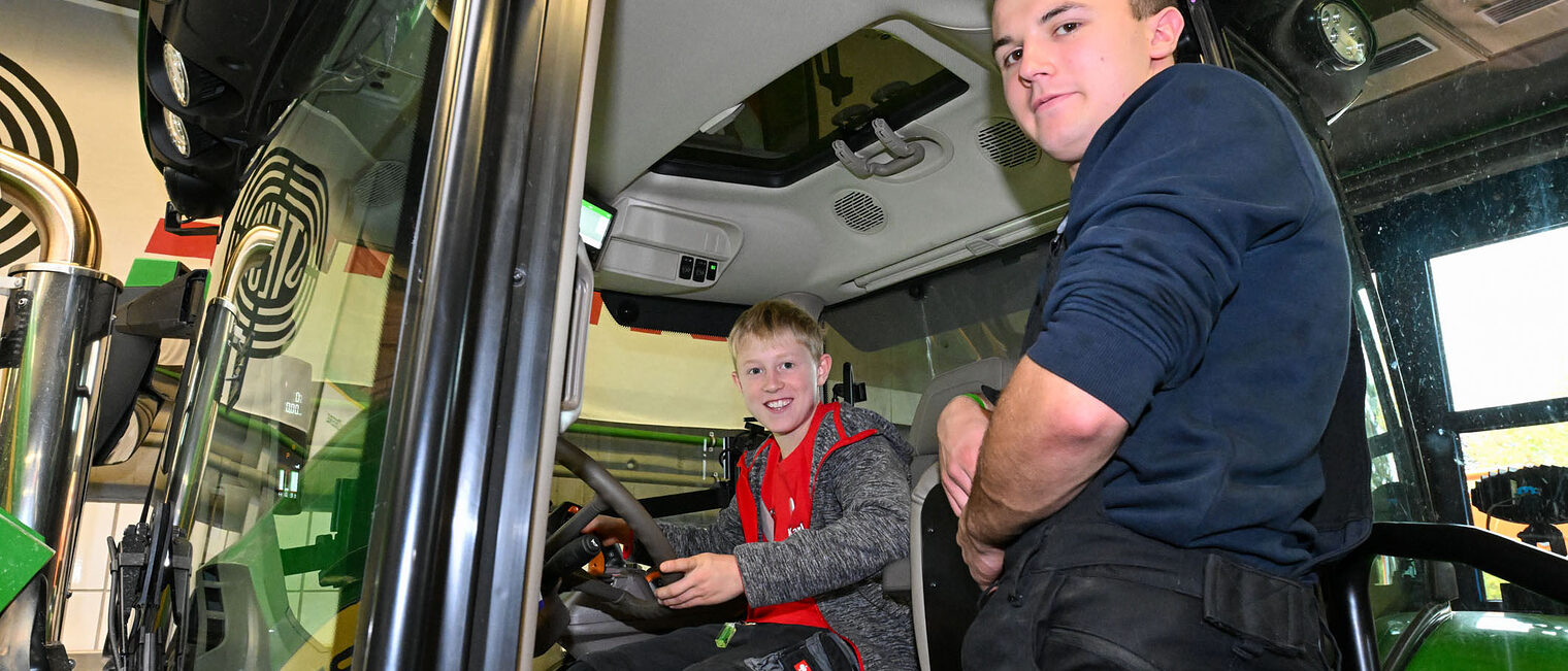 Eine Jugendliche sitzt in einem Traktor.