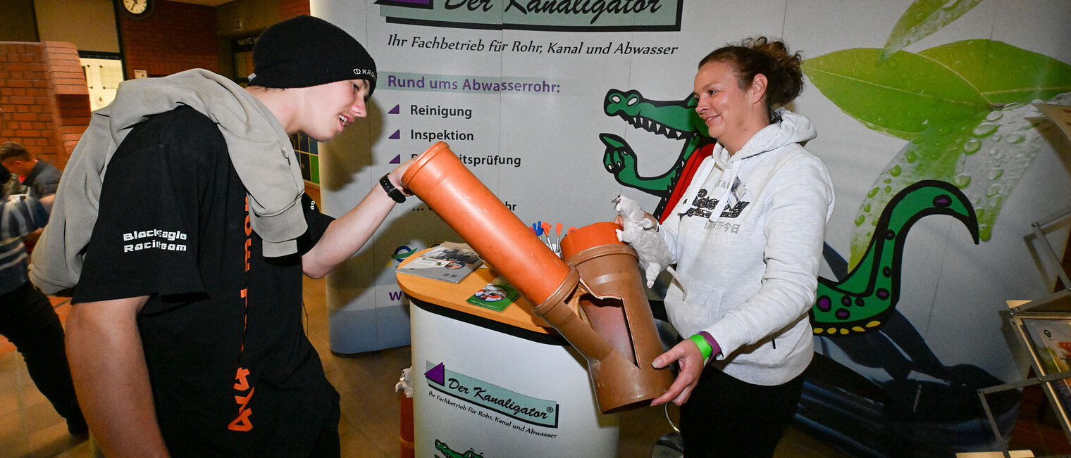 Ein Jugendlicher schaut sich eine Rohrverbindung an.