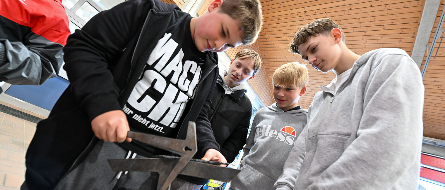 Ein Jugendlicher hackt ein Herz aus Schiefer zurecht.