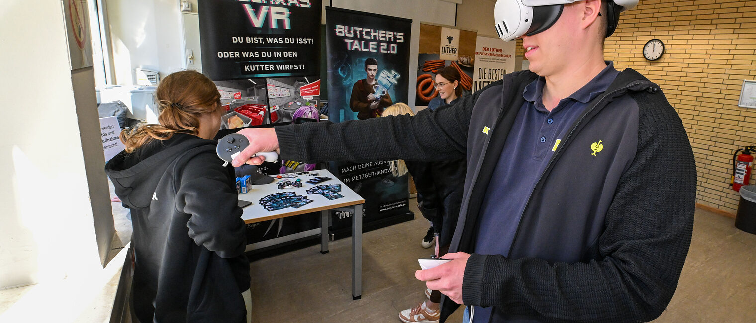 Ein Mann trägt eine VR-Brille und versucht sich beim Leberkäs VR. 