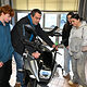 Ein Ausbilder zeigt drei Jugendlichen, wie sie ein Motorrad reparieren. 