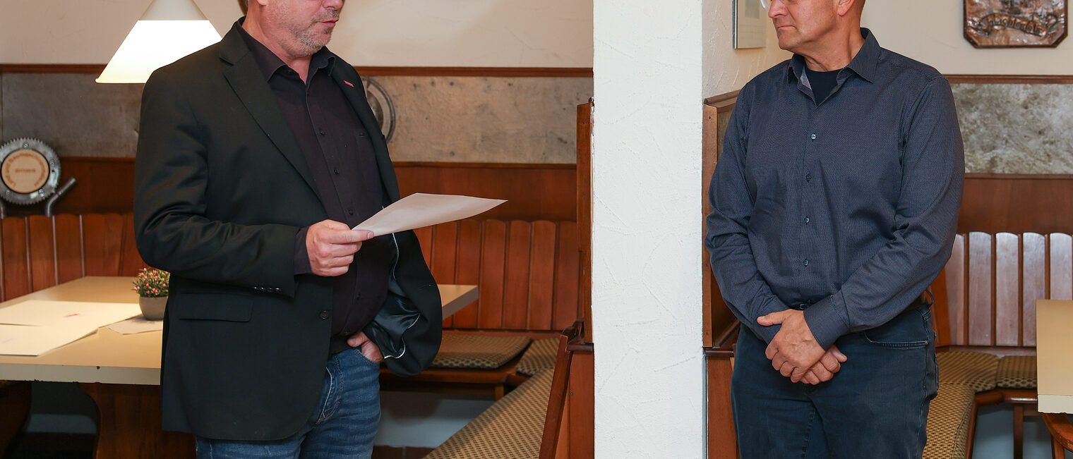 Jens Beland hält eine Rede während Oliver Krummholz zuhört.