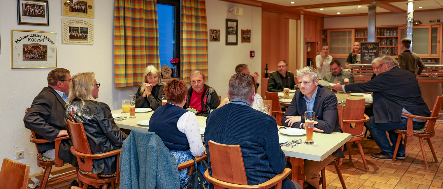 Die verdienten Ausbilder, Kreishandwerkermeister und HWK-Verantwortlichen sitzen an Tischen in der Zunftstube.