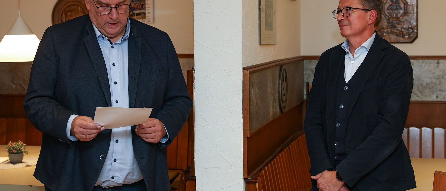 Reinhard Bauer hält eine Rede während Peter Hofmann zuhört.