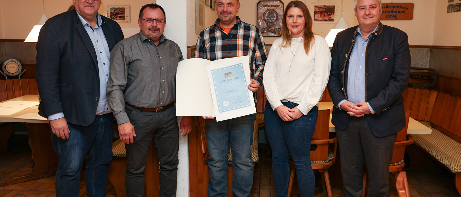 Dominik Grau präsentiert seine Ehrenurkunde zusammen seiner Frau und Reinhard Bauer, Harald Sattler und Matthias Graßmann.
