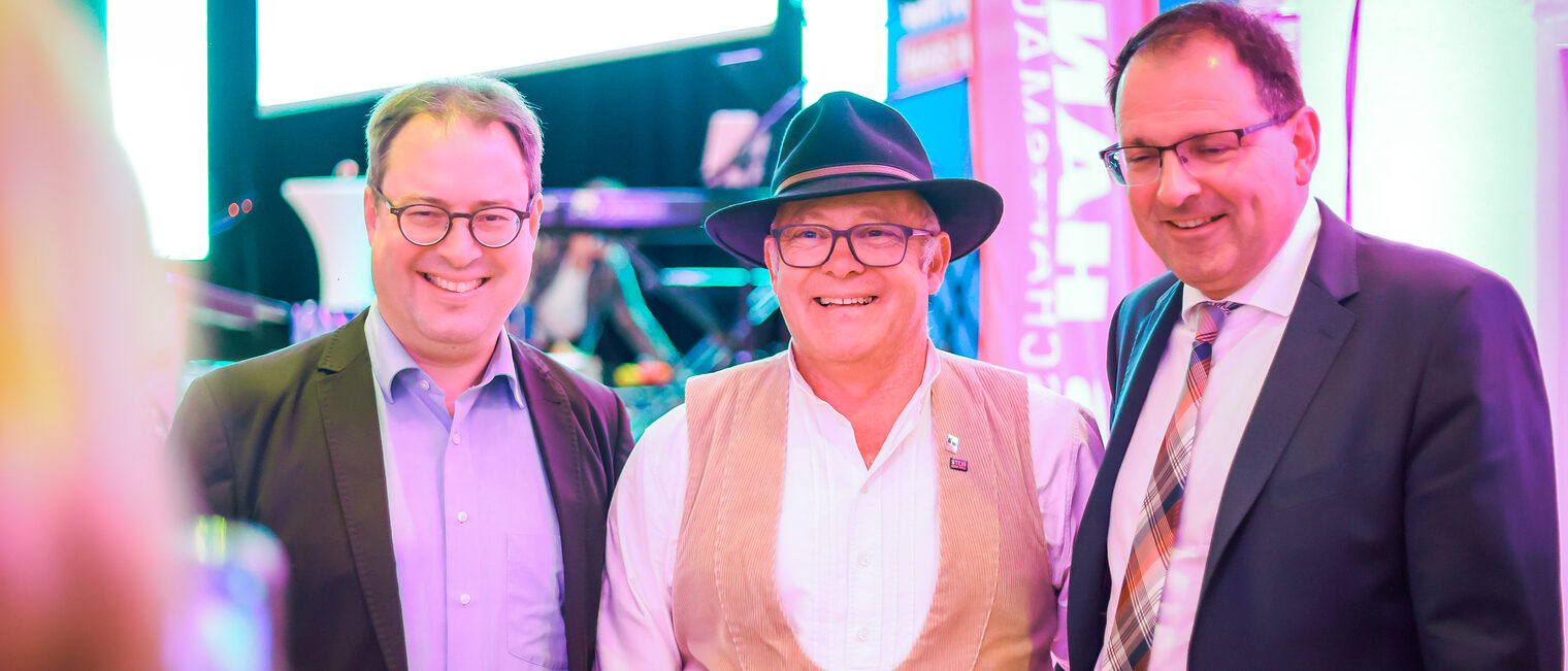 Politiker posieren mit einem Landessieger für ein Foto.