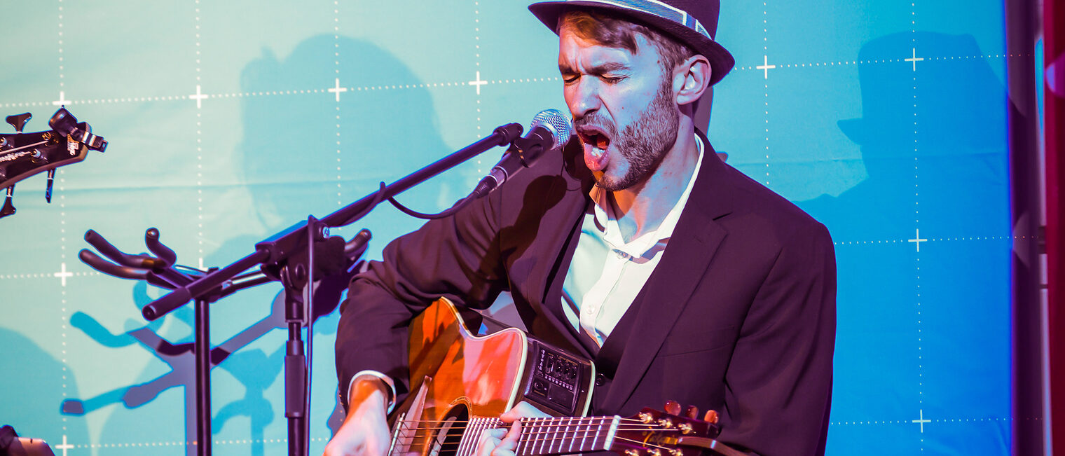 Ein Musiker mit Gitarre und Mikrofon macht Musik.