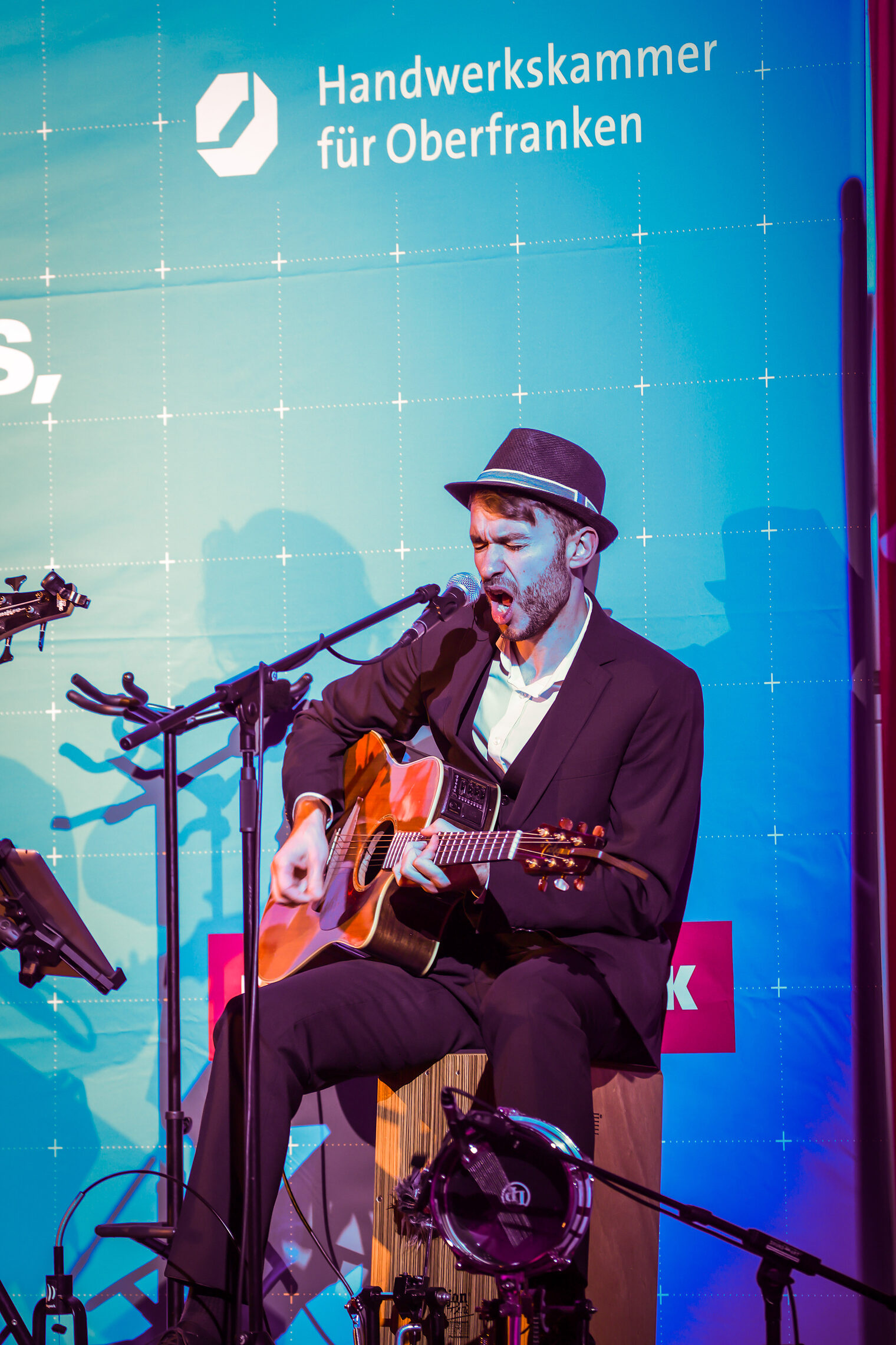 Ein Musiker mit Gitarre und Mikrofon macht Musik.