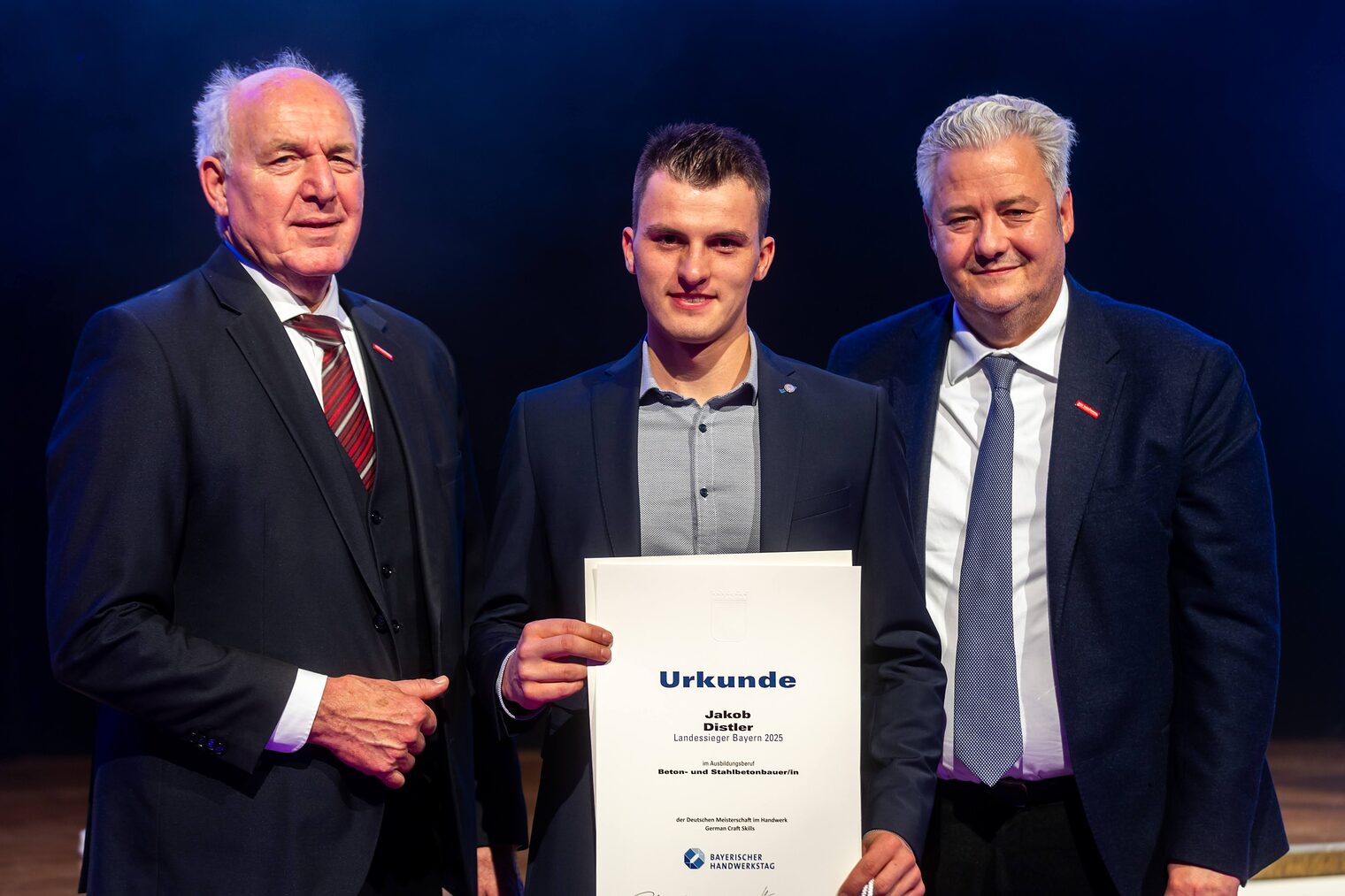 Jakob Distler präsentiert seine Urkunde mit BHT-Präsident Peterandl und HWK-Präsident Matthias Graßmann.