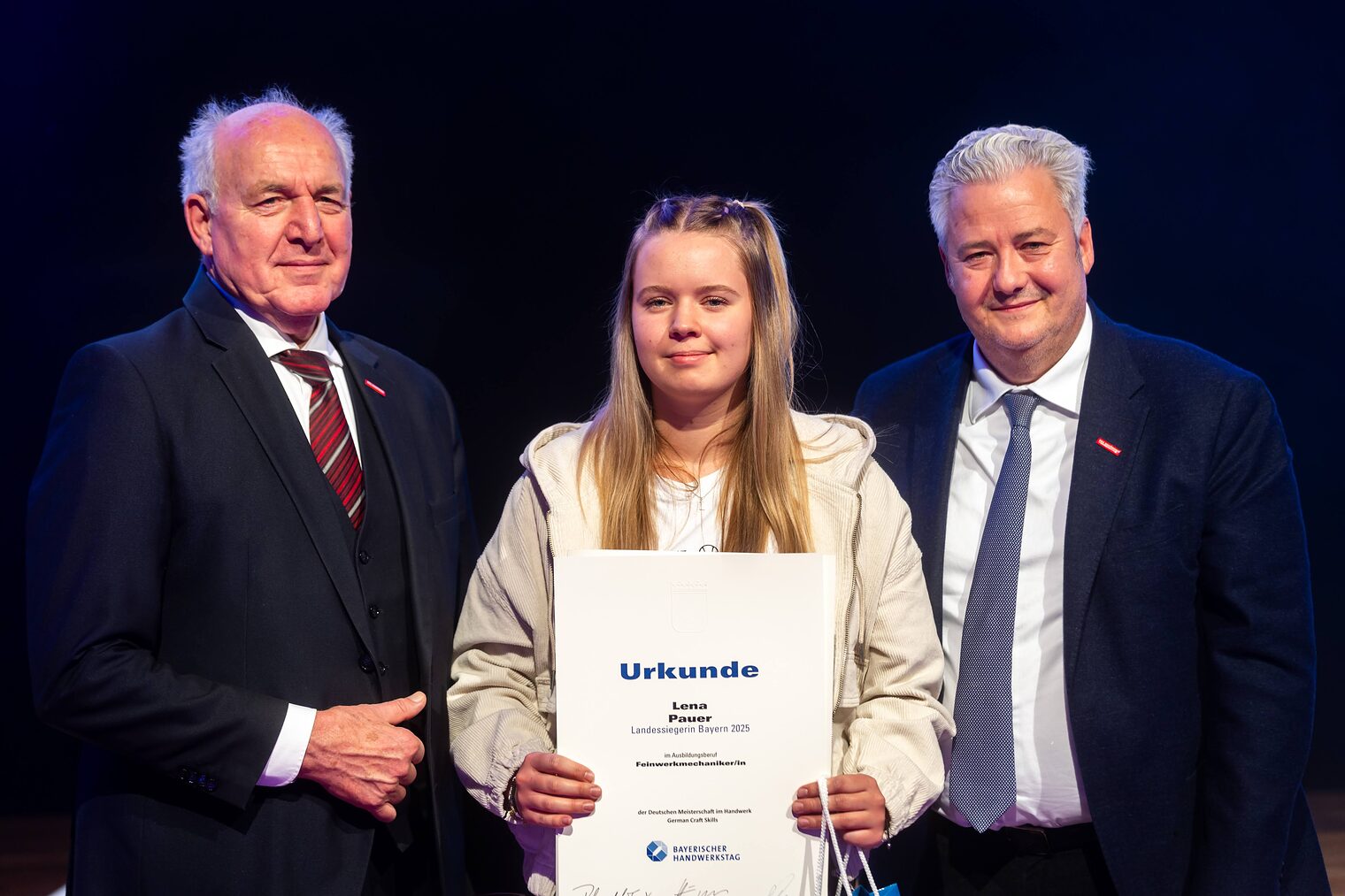 Lena Pauer präsentiert ihre Urkunde mit BHT-Präsident Peterandl und HWK-Präsident Matthias Graßmann.