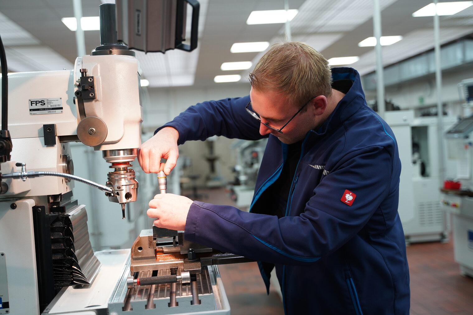 Ein Mann arbeitet an einer Drehmaschine. 