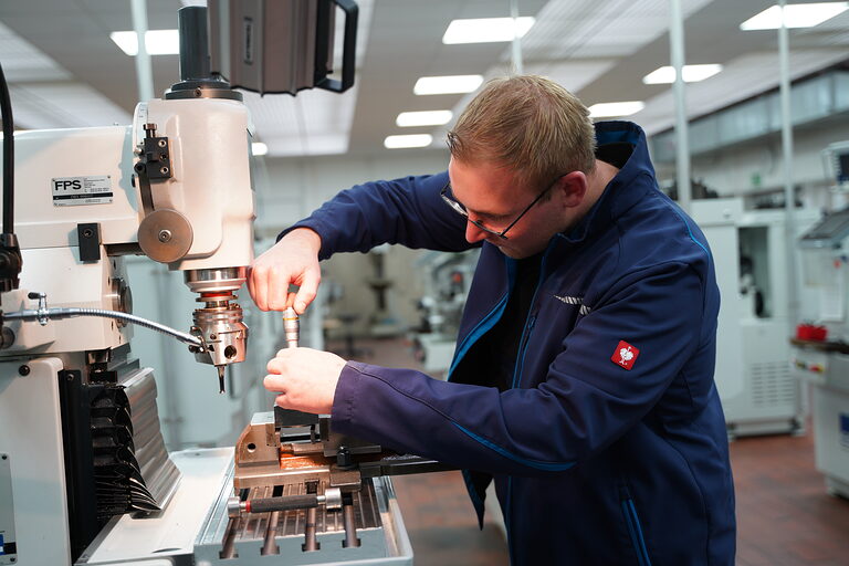 Ein Mann arbeitet an einer Drehmaschine. 