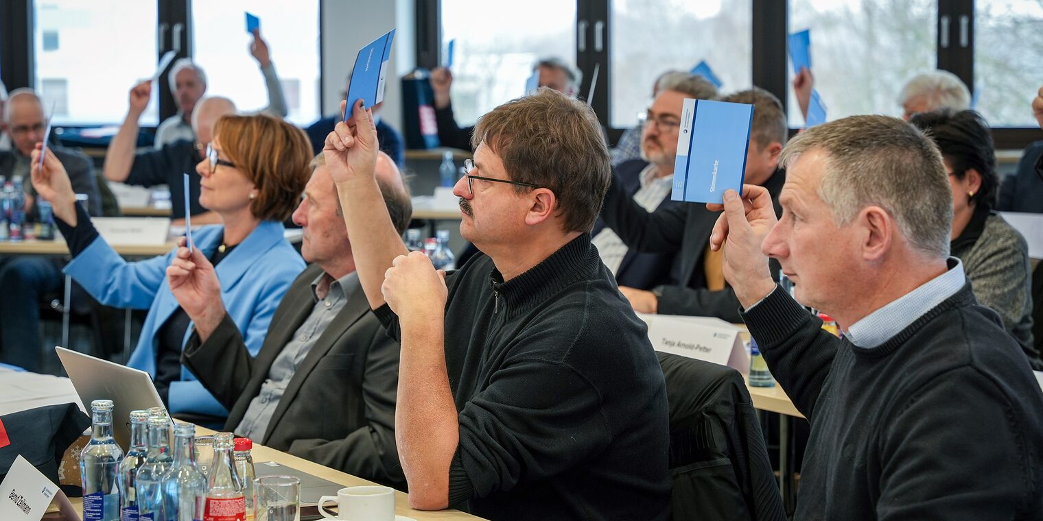 Die Mitglieder der Vollversammlung stimmen mit Stimmkarten ab.
