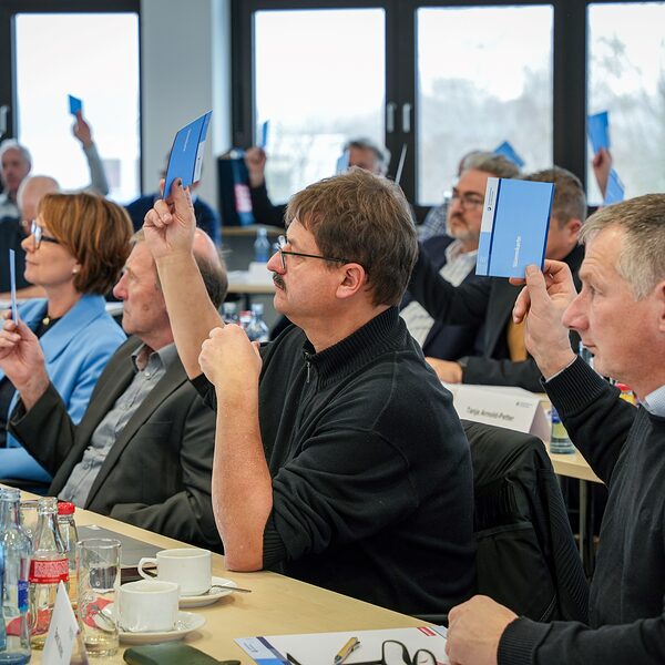 Die Mitglieder der Vollversammlung stimmen mit Stimmkarten ab.